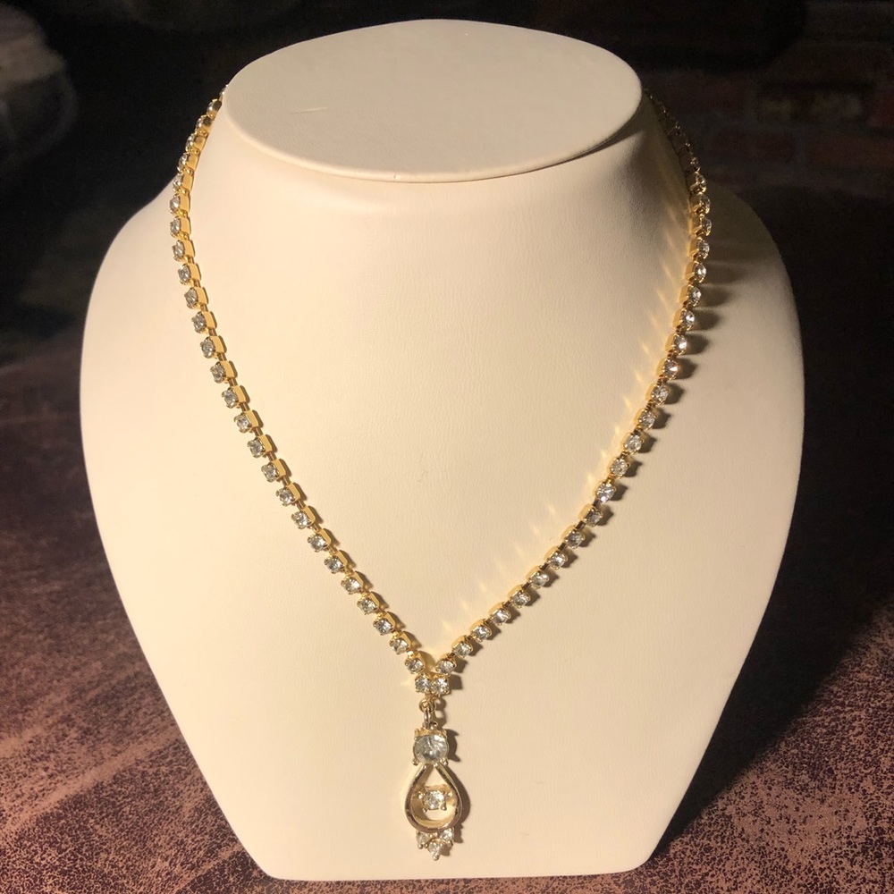 Rhinestone necklace set in a gold tone chain.